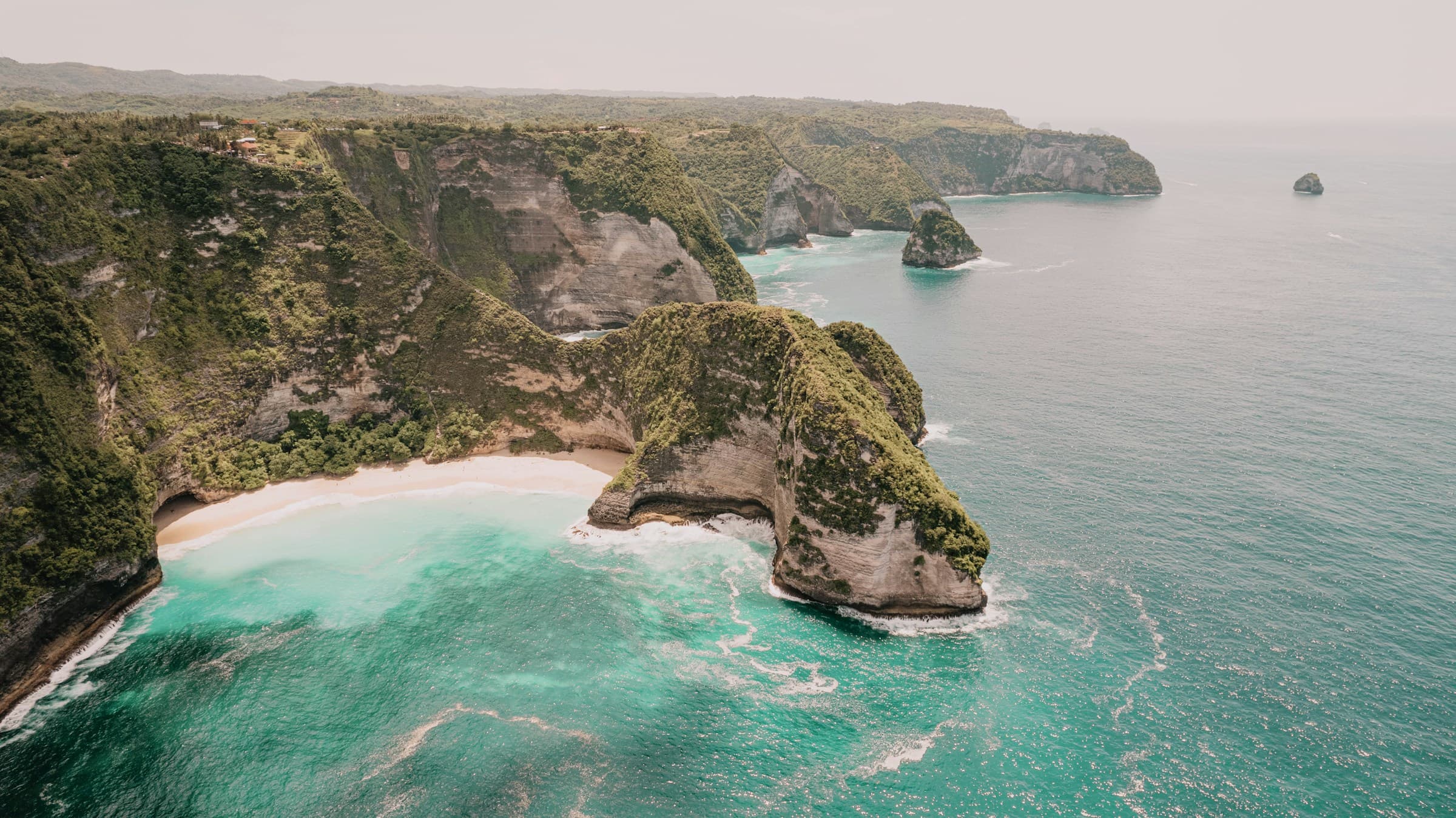 Pantai Bali dengan tas anyaman Easthtic dan topi oval di cahaya matahari